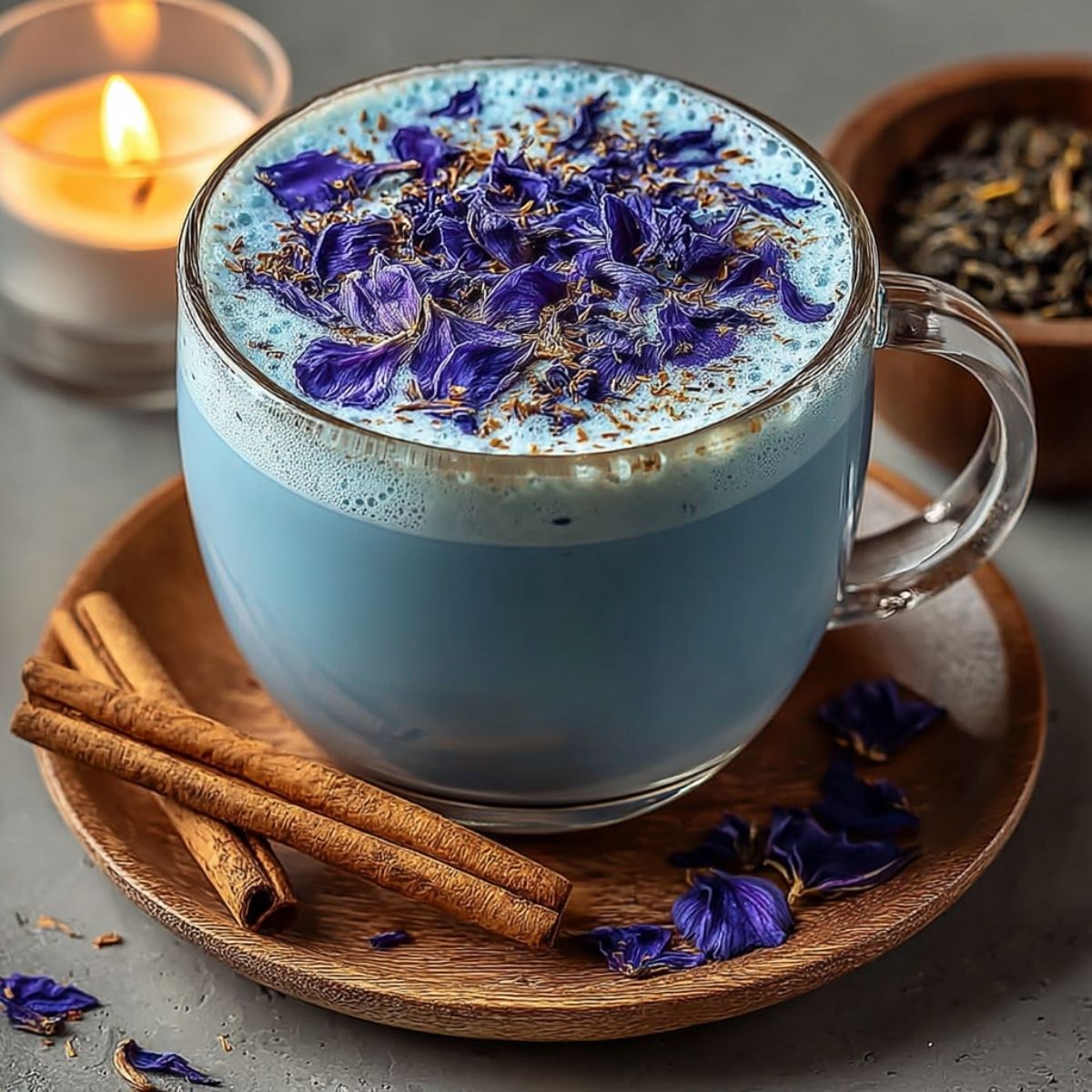 Moon Milk Tea on a modern marble countertop, showcasing its stunning blue color with creamy foam and butterfly pea flowers